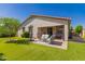 Beautiful backyard featuring a lush lawn, mature trees, and a covered patio with seating at 17825 W Lincoln St, Goodyear, AZ 85338