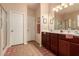 Well-lit bathroom featuring double sinks, cherry cabinets, and tile flooring at 17825 W Lincoln St, Goodyear, AZ 85338