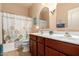 Bathroom featuring double sink vanity, neutral walls, and decorative accents at 17825 W Lincoln St, Goodyear, AZ 85338
