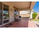 Cozy covered patio with seating, a wall clock, and a view of the landscaped backyard at 17825 W Lincoln St, Goodyear, AZ 85338
