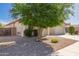 Landscaped front yard with mature tree and low maintenance desert landscaping at 17825 W Lincoln St, Goodyear, AZ 85338