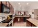 Open concept kitchen featuring granite countertops, dark wood cabinets, and sleek appliances at 17825 W Lincoln St, Goodyear, AZ 85338