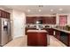 Charming kitchen featuring a central island, dark wood cabinets and stainless steel appliances at 17825 W Lincoln St, Goodyear, AZ 85338