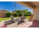 Relaxing covered patio with comfortable seating, outdoor decor, and a well-maintained yard at 17825 W Lincoln St, Goodyear, AZ 85338