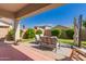 Charming covered patio with comfortable seating, lush landscaping, and a serene backyard view at 17825 W Lincoln St, Goodyear, AZ 85338