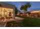 Charming covered patio with outdoor seating, complemented by a lush lawn and well-manicured landscaping at 2045 E San Carlos Pl, Chandler, AZ 85249