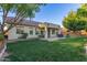 Serene backyard featuring a covered patio with seating, lush lawn, and mature trees, perfect for enjoying outdoor living at 2045 E San Carlos Pl, Chandler, AZ 85249