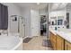 Bathroom featuring soaking tub, glass shower, double sinks, and neutral tile at 2045 E San Carlos Pl, Chandler, AZ 85249