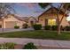 Charming single-story home featuring a well-maintained lawn and a two-car garage during a colorful sunset at 2045 E San Carlos Pl, Chandler, AZ 85249