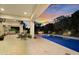Stunning backyard featuring a pristine pool, covered patio, and a cozy outdoor fireplace at sunset at 20644 E Sunrise Ct, Queen Creek, AZ 85142