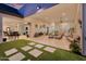 Spacious covered patio area featuring an outdoor kitchen, pool, and lounge area for elegant outdoor living and entertaining at 20644 E Sunrise Ct, Queen Creek, AZ 85142
