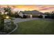 Wide driveway leads to this home's three-car garage, surrounded by green grass and vibrant shrubbery at 20644 E Sunrise Ct, Queen Creek, AZ 85142