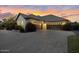 Exterior shot showcasing a three-car garage and a wide brick driveway surrounded by manicured landscaping at 20644 E Sunrise Ct, Queen Creek, AZ 85142