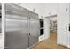 Modern kitchen showcasing stainless steel refrigerator, double ovens, and custom white cabinets with pantry access at 20644 E Sunrise Ct, Queen Creek, AZ 85142