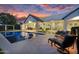 Luxurious backyard with a sparkling pool, comfortable seating, and a serene atmosphere at twilight at 20644 E Sunrise Ct, Queen Creek, AZ 85142