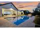 Stunning backyard pool with a fire pit and manicured landscaping under a colorful twilight sky at 20644 E Sunrise Ct, Queen Creek, AZ 85142