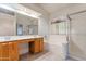 Bathroom featuring dual vanities, a bathtub, and a glass-enclosed shower at 20986 N 66Th Ln, Glendale, AZ 85308