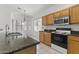 Efficient kitchen featuring oak cabinets, granite counters, tile flooring, and stainless appliances at 20986 N 66Th Ln, Glendale, AZ 85308