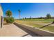 Scenic backyard patio with golf course views and mature palm trees in the community at 2211 N Recker Rd, Mesa, AZ 85215