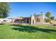 A view of the back of the property, showing the red tiled roofline and lush green lawn at 2211 N Recker Rd, Mesa, AZ 85215