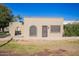 Charming single-story home with neutral stucco, a decorative archway, and a desert-friendly yard at 2211 N Recker Rd, Mesa, AZ 85215