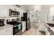 Open kitchen with stainless steel appliances, white cabinetry, granite countertops, and views to breakfast nook at 2211 N Recker Rd, Mesa, AZ 85215