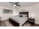 Primary bedroom with a large window, ceiling fan, wood furniture, and carpet with textured area rug at 2211 N Recker Rd, Mesa, AZ 85215