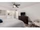 Primary bedroom features ensuite bathroom, dresser with mounted TV, and ceiling fan at 2211 N Recker Rd, Mesa, AZ 85215