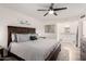 Primary bedroom with ceiling fan, wood furniture, and ensuite bathroom with large vanity at 2211 N Recker Rd, Mesa, AZ 85215