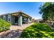 Inviting covered patio with stylish seating overlooks the lush green lawn and landscaped backyard at 23179 S 225Th Pl, Queen Creek, AZ 85142