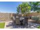 This is an outdoor dining area with a large table, six chairs, and a large umbrella for shade at 23179 S 225Th Pl, Queen Creek, AZ 85142