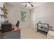 This is a bedroom with neutral walls, a window, a ceiling fan, a shelf, a desk, and workout equipment at 23179 S 225Th Pl, Queen Creek, AZ 85142