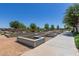 Community garden beds lining a sidewalk in a park setting with mature trees at 23179 S 225Th Pl, Queen Creek, AZ 85142