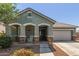 Charming exterior of a single-story home with stone accents, covered porch, and well-maintained landscaping at 23179 S 225Th Pl, Queen Creek, AZ 85142