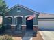 Charming home featuring a covered porch with stone accents and a white rocking chair under an American flag at 23179 S 225Th Pl, Queen Creek, AZ 85142