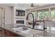 Close-up of kitchen island featuring a sink and a view of the living room fireplace at 23179 S 225Th Pl, Queen Creek, AZ 85142