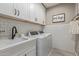 Functional laundry room featuring white cabinets, subway tile backsplash, and modern washer/dryer units at 23179 S 225Th Pl, Queen Creek, AZ 85142