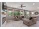 Cozy living room with a fireplace, large windows, and an inviting sectional sofa, perfect for relaxation at 23179 S 225Th Pl, Queen Creek, AZ 85142
