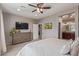Spacious main bedroom features a neutral color palette, ceiling fan, and dresser with TV at 23179 S 225Th Pl, Queen Creek, AZ 85142