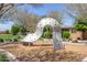 Community playground featuring a climbing structure over wood chip surfacing, surrounded by trees and grass at 23179 S 225Th Pl, Queen Creek, AZ 85142