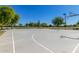 Well-maintained outdoor basketball court with multiple hoops surrounded by trees and green space under a clear blue sky at 2368 E Bellerive Dr, Gilbert, AZ 85298