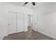 Bright bedroom features wood-look floors, ceiling fan, and closet with sliding doors at 2368 E Bellerive Dr, Gilbert, AZ 85298