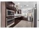Modern kitchen boasts stainless steel appliances, dark wood cabinets, granite countertops, and stylish tile flooring at 2368 E Bellerive Dr, Gilbert, AZ 85298