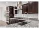 Close-up of a modern kitchen featuring stainless steel appliances, granite countertops, and dark wood cabinets at 2368 E Bellerive Dr, Gilbert, AZ 85298