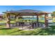 Charming covered picnic area featuring multiple tables and grills, set against a backdrop of a serene lake at 2368 E Bellerive Dr, Gilbert, AZ 85298