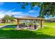 Charming picnic area with covered tables and a grill is surrounded by green space and a scenic lake view at 2368 E Bellerive Dr, Gilbert, AZ 85298