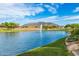 Scenic pond view with a fountain and mountain backdrop, enhanced by lush landscaping and mature trees at 2368 E Bellerive Dr, Gilbert, AZ 85298