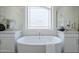 Elegant soaking tub as part of the main bath with dual sinks and plenty of natural light at 24000 S 218Th Pl, Queen Creek, AZ 85142