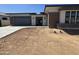 Charming single-story home featuring a brick accent wall, gray garage door, and desert landscaping at 24000 S 218Th Pl, Queen Creek, AZ 85142