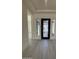 Bright foyer with light wood flooring and a decorative black front door at 24000 S 218Th Pl, Queen Creek, AZ 85142